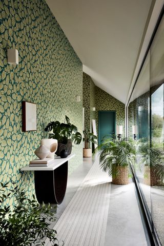 hallway with fully glazed wall and bold botanical wallpaper