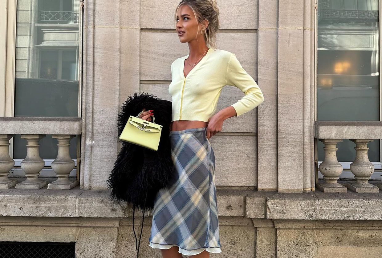 Woman in yellow cardigan and plaid skirt