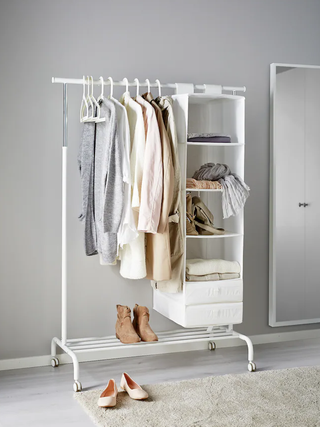 A white clothing rack against a gray wall