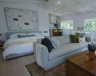 living space with neutral scheme with bed, sofa and artwork