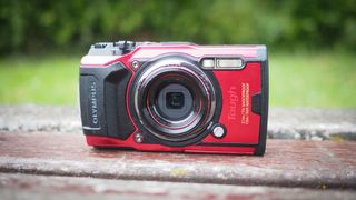 Olympus Tough TG-6 on a wooden bench in front of green grass