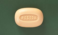 A cream coloured bar of soap with the word "Reseda" imprinted on it