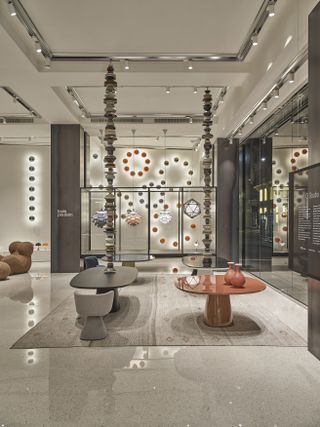 Interiors of D Studio Milano with high ceilings and two dining tables by Monica Armani for B&B in grey and red