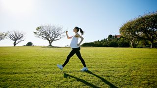 Pregnant woman walking through park.