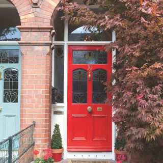 Front entrance with red front door and brick archway