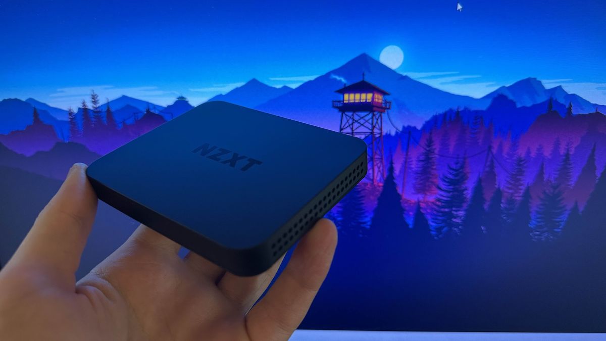 The NZXT Signal HD60 being held in front of a purple Firewatch game background 