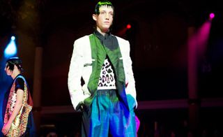 male model on a fashion week runway wearing a white and green blazer