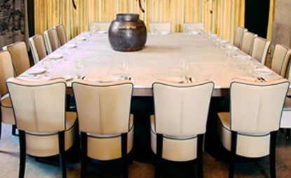 Interior view of the Museu da Cerveja. The focal point is a large table that sits 18 people, with white linen and beige chairs.