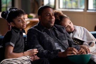 Kenan and his daughters watch tv together in the show 'Kenan.' 