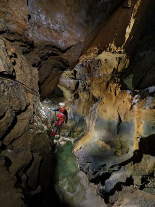 Photograph titled Pete Hall Los Gours down Coventosa Cave Cantabria Spain. Photographed by Sam Davis