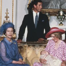 Princess Diana wears a pink floral dress and pink hat to hold Prince William on August 4, 1982 at his royal christening