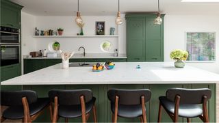Green kitchen with large kitchen with white marble countertops and large kitchen island