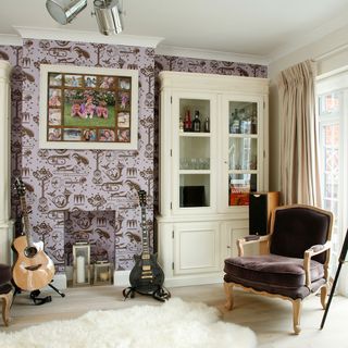 music room with wallpaper on wall and cabinet with guitar