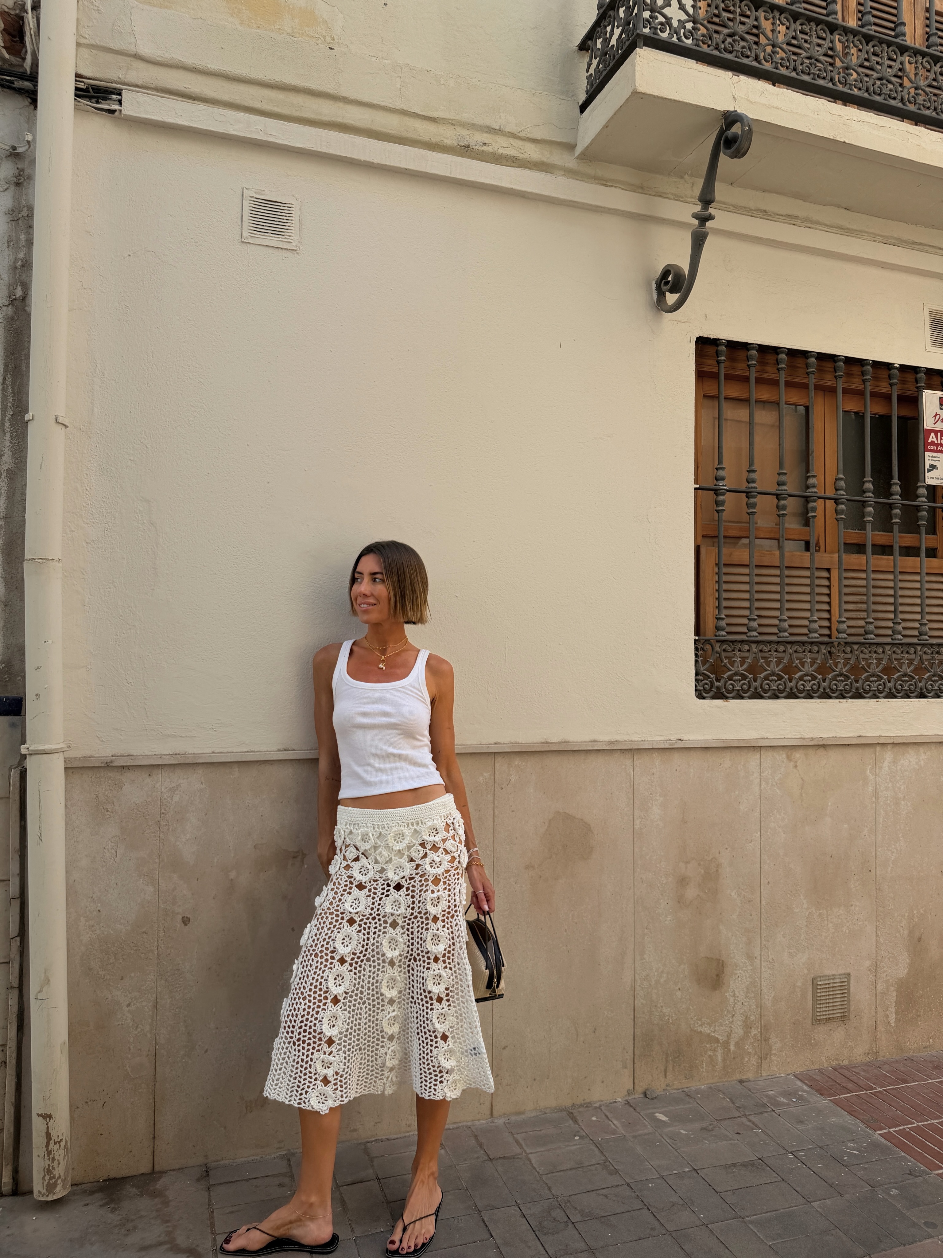 Hannah in a white vest and crochet skirt