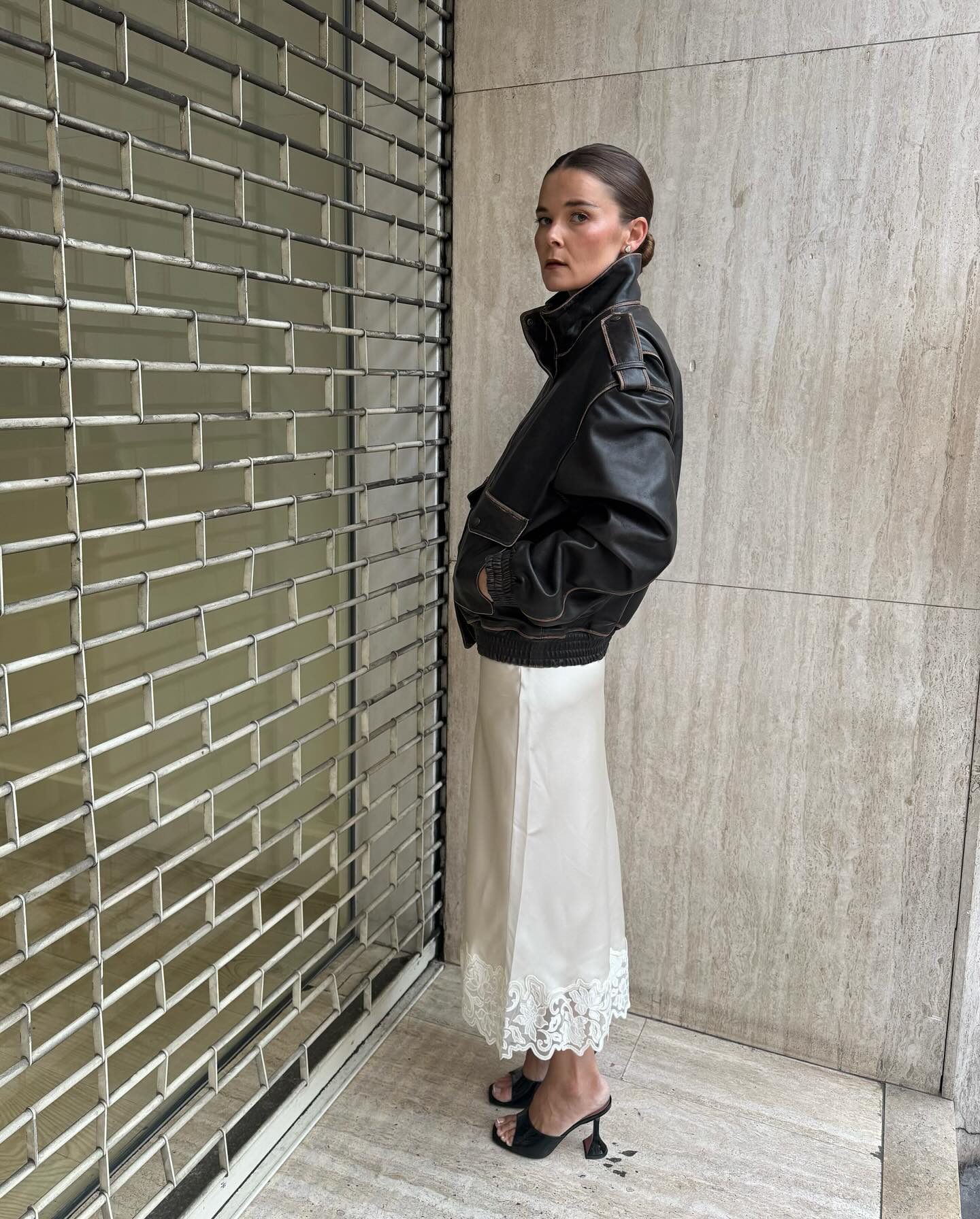 Rikke Krefting wearing a leather bomber jacket and cream lace-trim skirt.