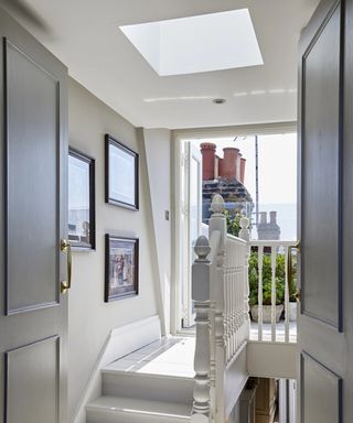 white painted landing with roof light and large opening onto small balcony