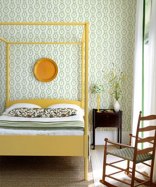 Bedroom paint ideas with yellow painted four poster bed and green floral wallpaper