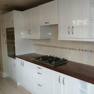 white kitchen units with dark wood worktop