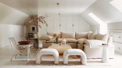 white living room with cream sofa, armchairs, and curved ottoman