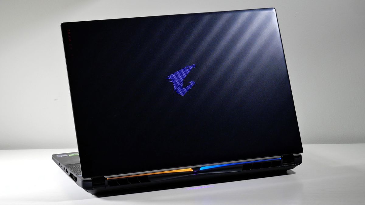 Gigabyte Aorus Master 16 (RTX 5080) opened on a white table with its lid facing the camera, highlighting its dark blue color with wave-like pattern.
