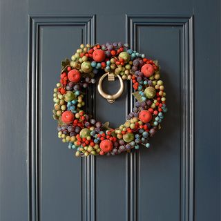 christmas wreath with frosted fruits on blue door
