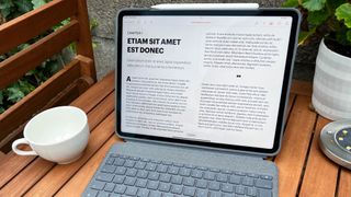 A photograph of the 12.9in Apple iPad Pro on a garden table with a keyboard case