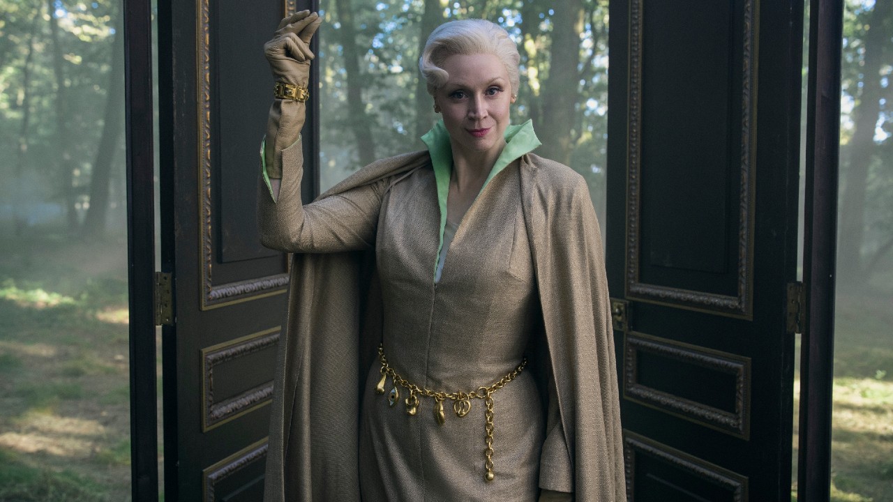 Gwendoline Christie as Principal Weems holding up her left hand and snapping in Wendesday.