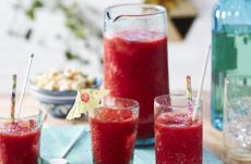 Boozy slushie cocktail with strawberries and rose lemonade