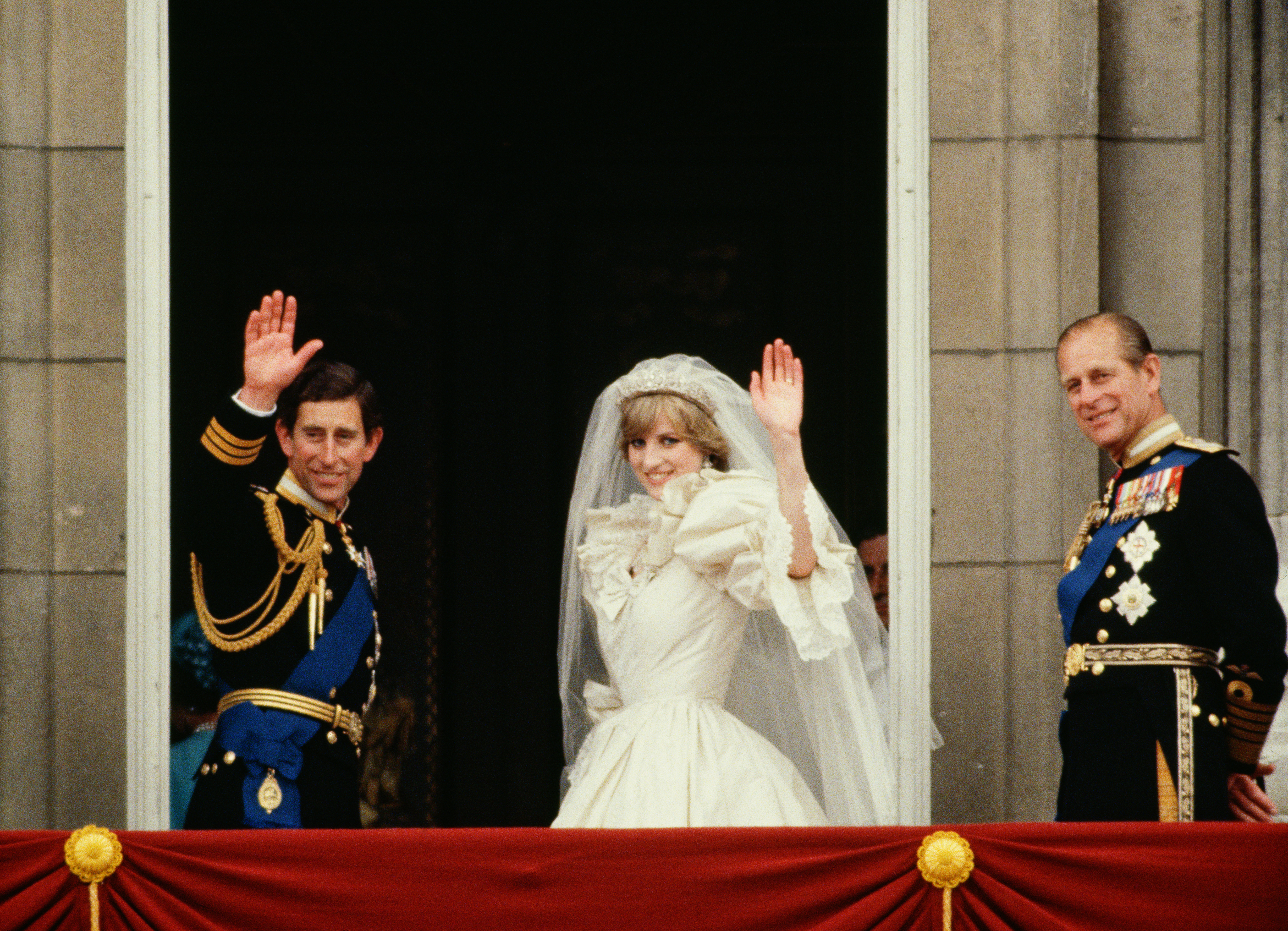 Prince Charles and Princess Diana waving on their wedding day next to Prince Philip