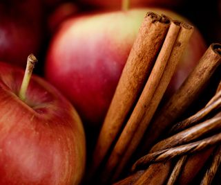 A close up of red apples with cinnamon sticks