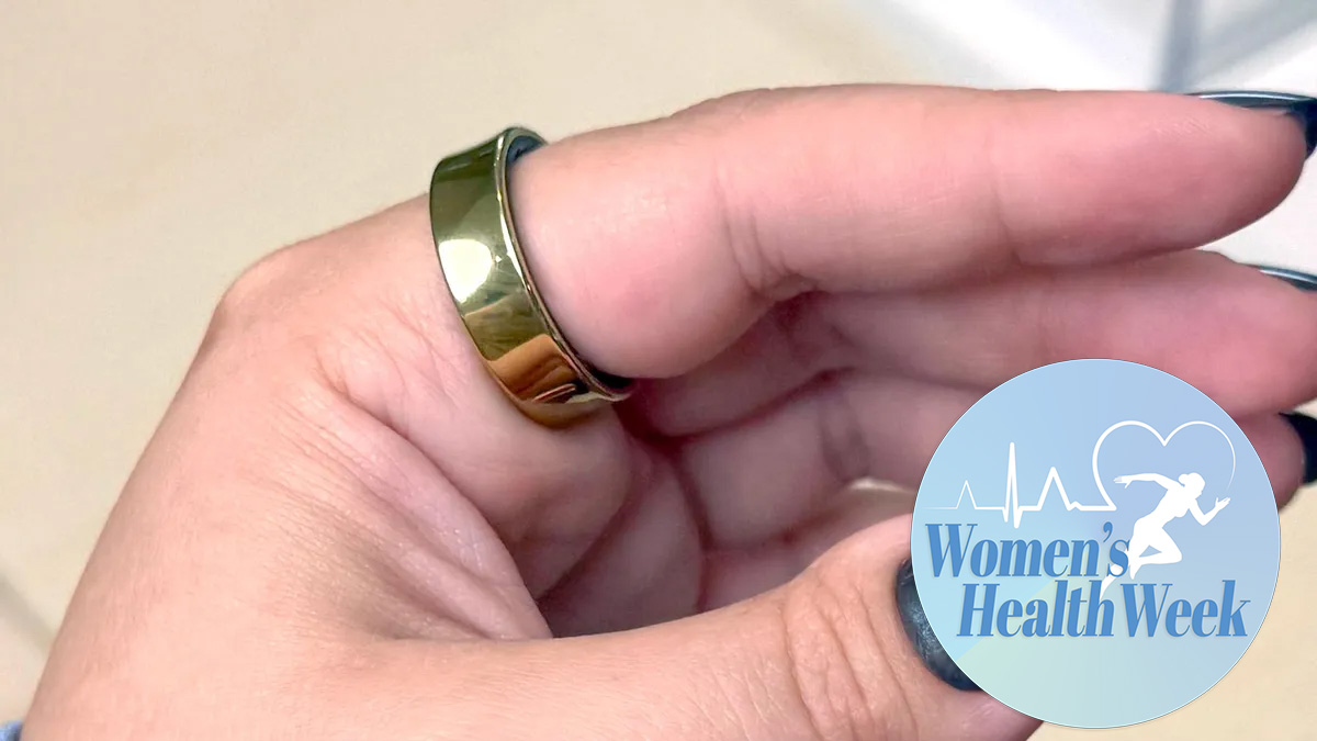 A gold Samsung Galaxy Ring shown on a woman&#039;s finger