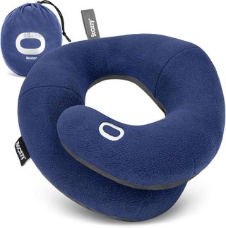 A dark blue BCOZZY travel pillow against a white background