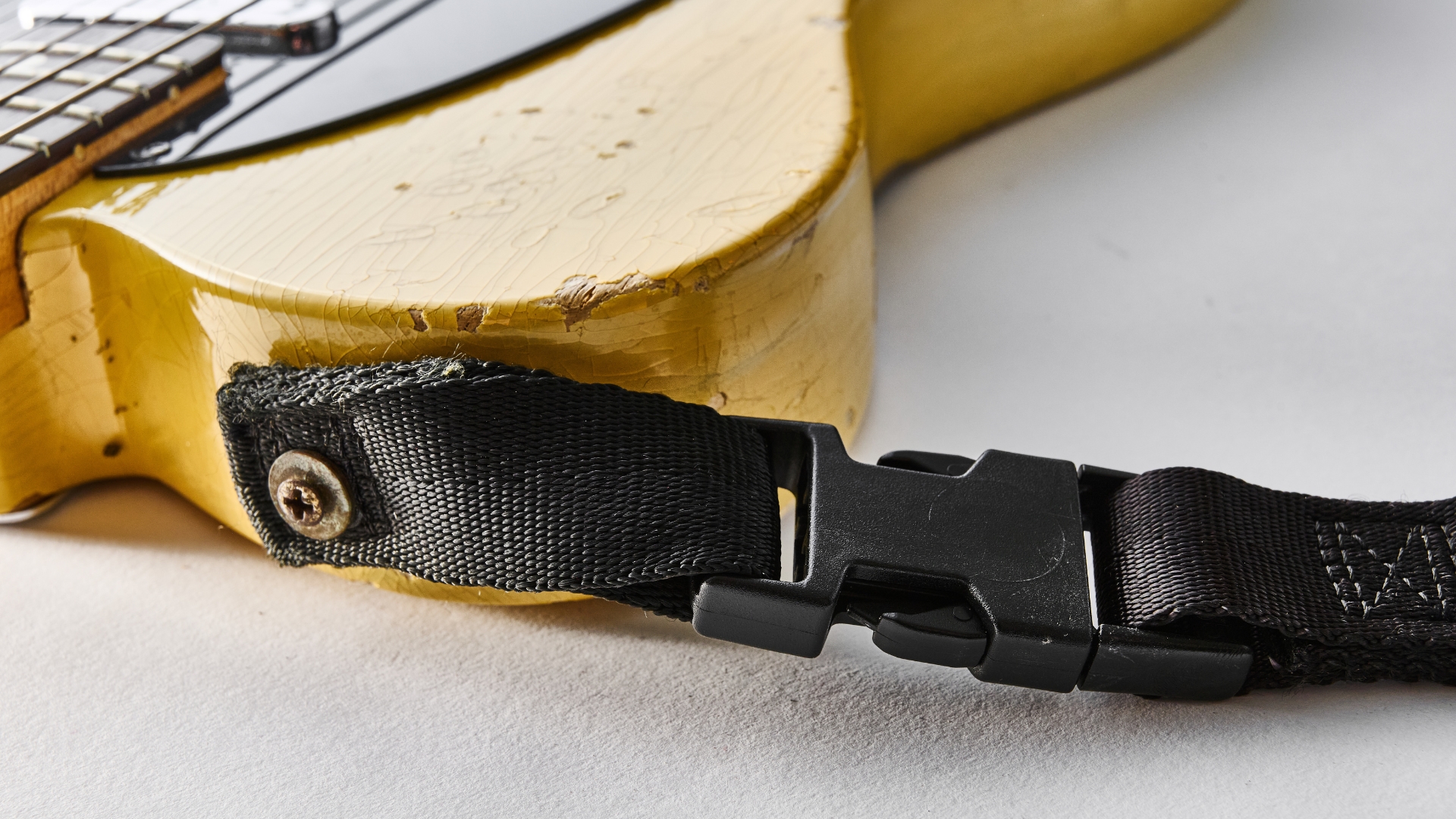 A very worn strap lock system on a Telecaster guitar