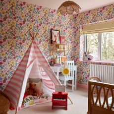 children's bedroom with floral wallpaper and pink and white striped tent 