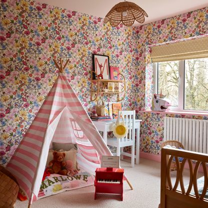 children's bedroom with floral wallpaper and pink and white striped tent