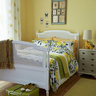 bedroom with yellow walls and white bed