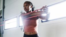 A woman performing woodchops with a resistance band