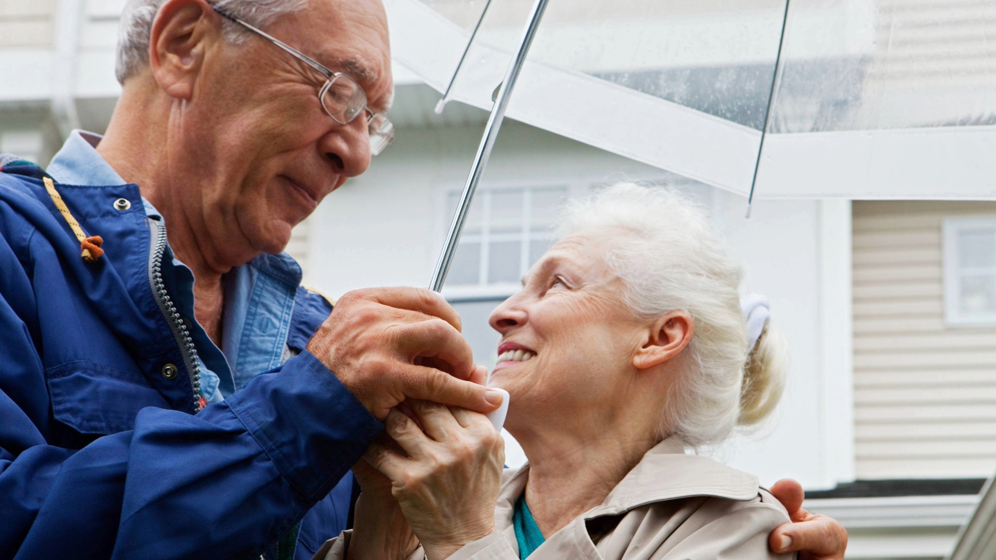 Senior couple under an umbrella outside