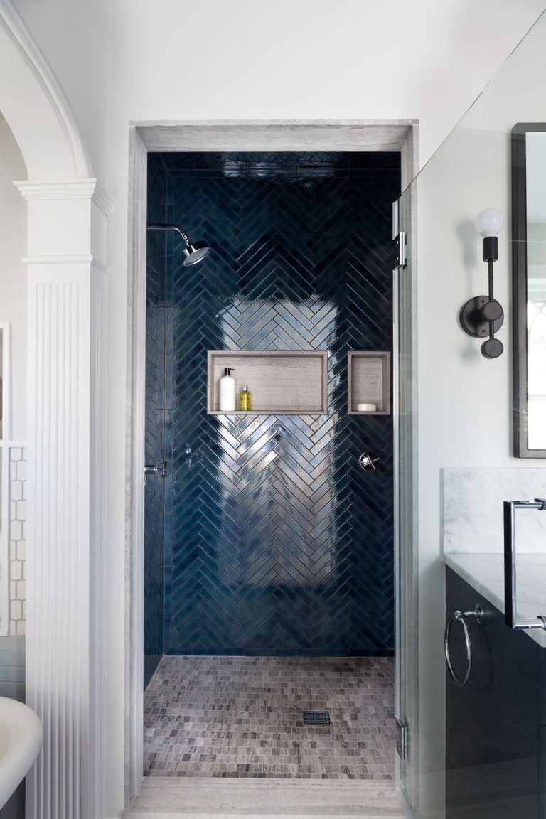 dark blue herringbone tiles in shower, grey tiled shower floor, inset shelf