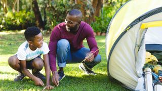 Father and son pitching a tent