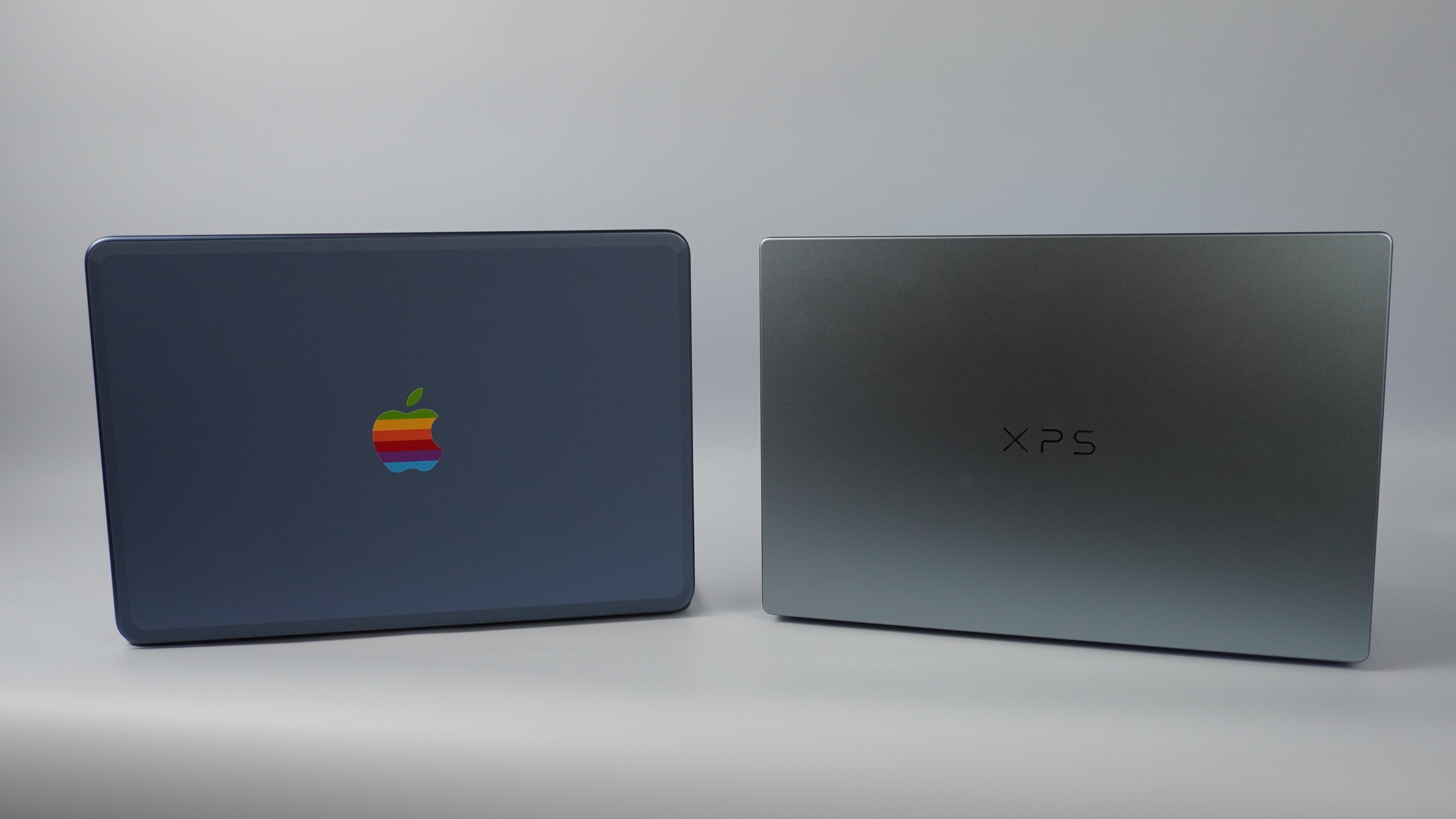 Dell XPS 13 (2026) در کنار MacBook Neo از پشت با درب باز