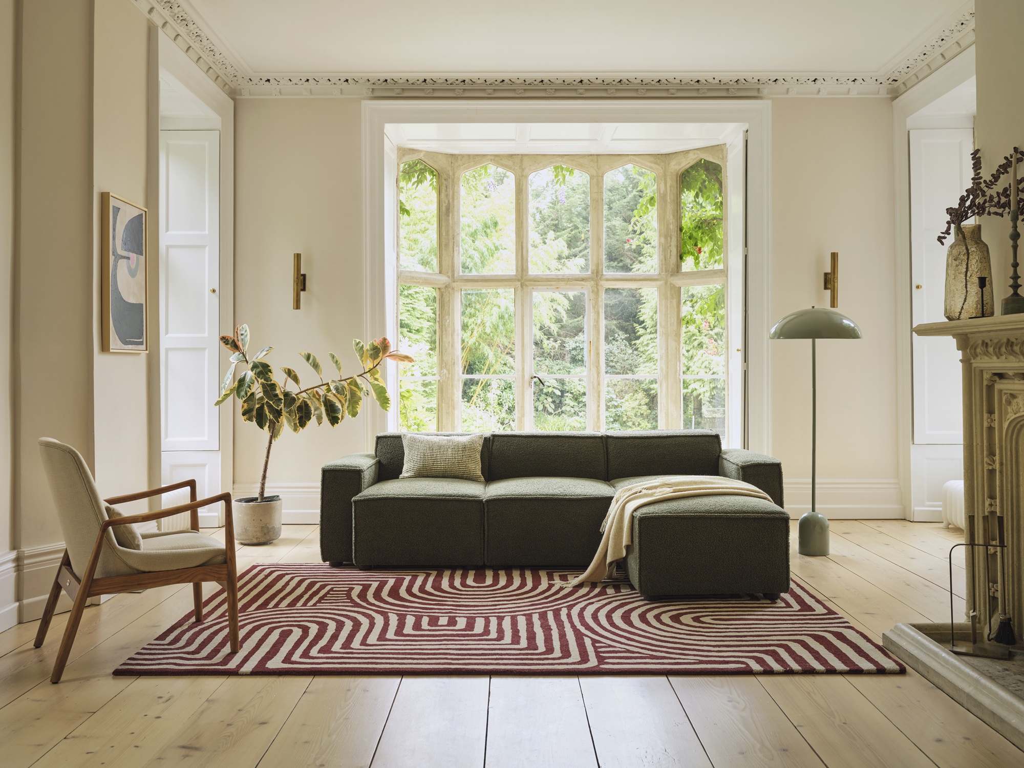 a green sofa in a living room with a patterned rug