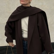 woman in brown coat, sweater, and jeans