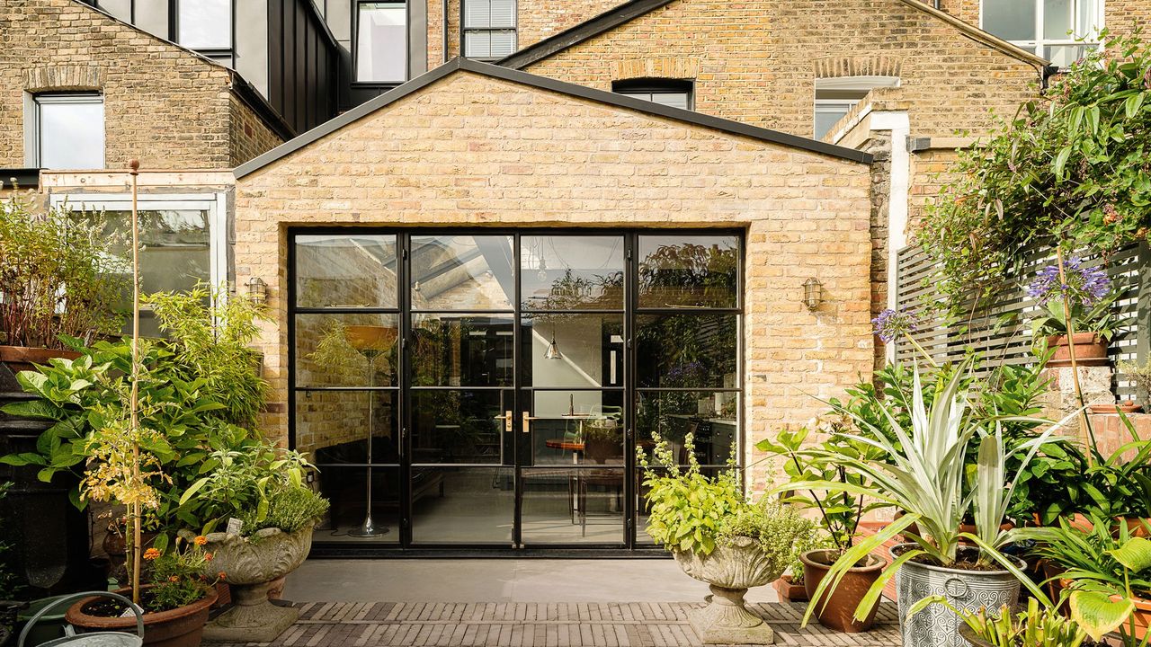 brick wall house glass door and plants