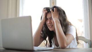 Woman looking stressed in front of laptop
