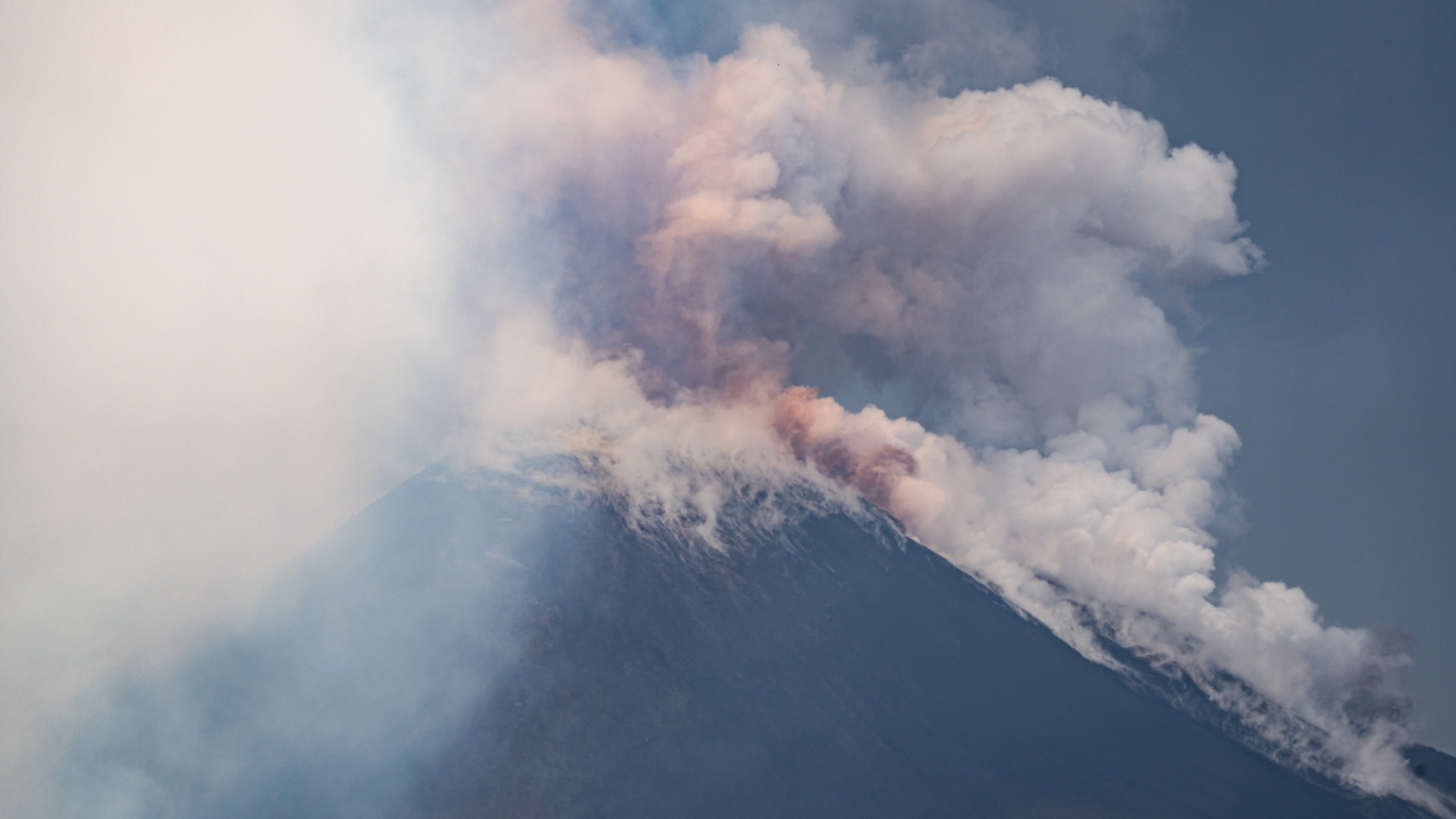 A close-up photograph of the summit of Mount Etna as it erupted with ash and other volcanic material.