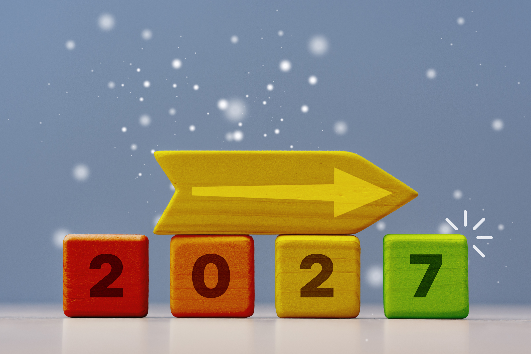 Creative business metaphor for long term strategy and goal setting. Wooden cubes with numbers representing the upcoming year 2027 and direction sign on blue background with copy space