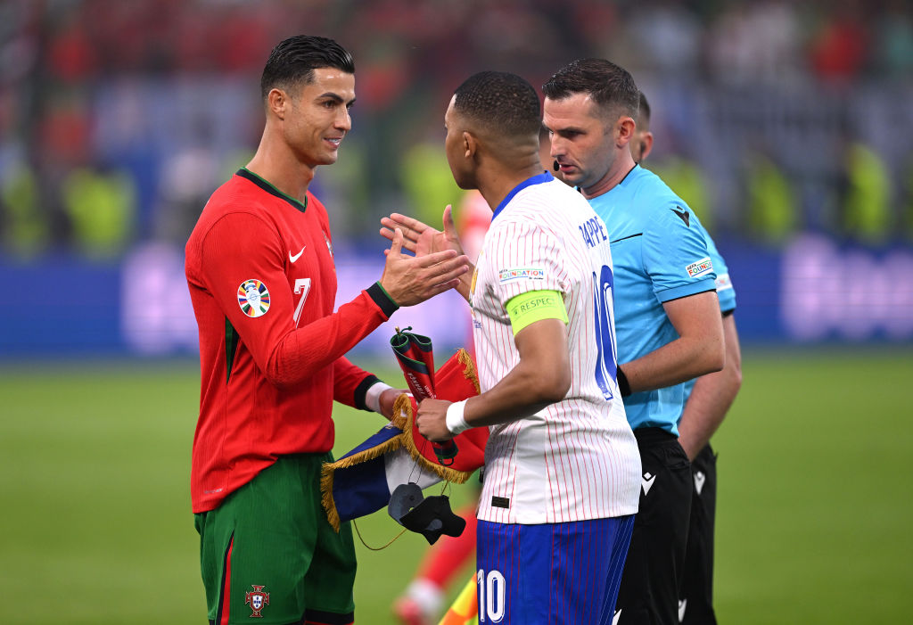 HAMBURG, GERMANY - JULY 05: Cristiano Ronaldo of Portugal shakes hands with Kylian Mbappe of France as they exchange pennants prior to the UEFA EURO 2024 quarter-final match between Portugal and France at Volksparkstadion on July 05, 2024 in Hamburg, Germany. (Photo by Stu Forster/Getty Images)