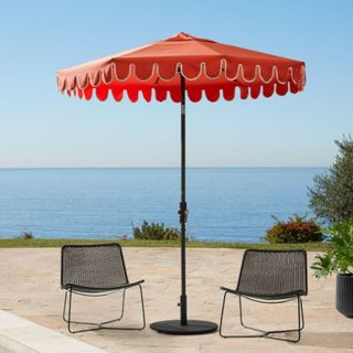 A red standing outdoor umbrella with scalloped white edges from West Elm