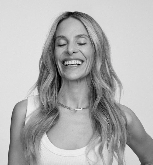 a black and white image of a woman with long hair laughing with eyes closed